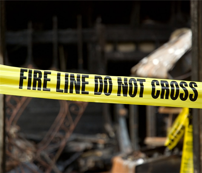 a fire damaged house with yellow fire line tape in front of the door